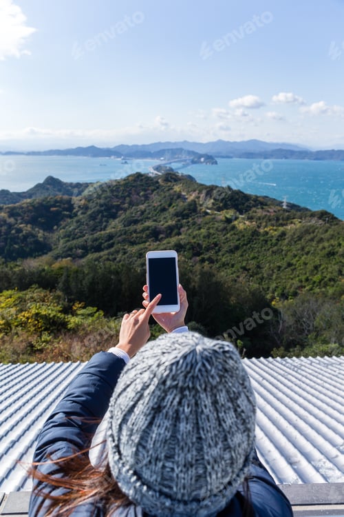 Preview: Woman using cellphone to take photo