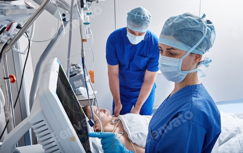 Preview: Nurses in intensive care unit of hospital checking vitals of hospitalized female patient. ICU