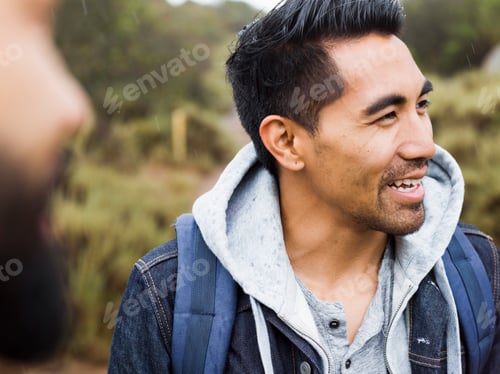 Preview: Two men, one smiling wearing a hooded top.