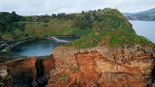 Preview: Drone green island lagoon cliff view. Rocky coastline with green lush vegetation