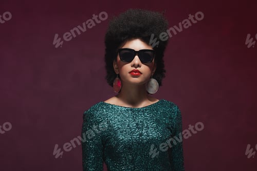Preview: Half Body Shot Of An Elegant Young Woman Wearing Glittery Green Dress With Sunglasses Against
