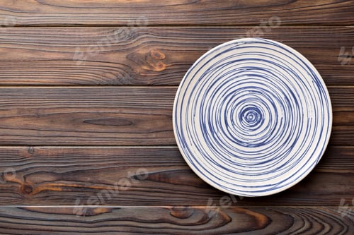 Preview: Top view of empty colorful plate on wooden background. Empty space for your design