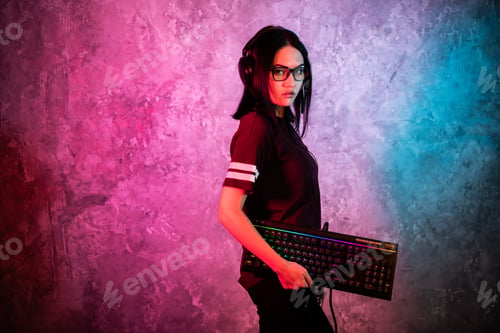 Preview: Funny nerd gamer girl posing with gaming keyboard, playing computer games