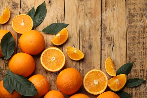 Preview: Fresh ripe oranges and leaves on wooden table, flat lay. Space for text
