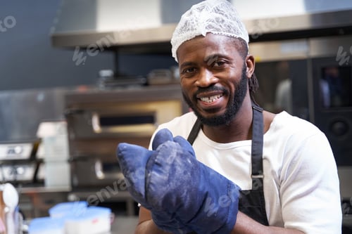 Preview: Smiling professional chef baking food in restaurant