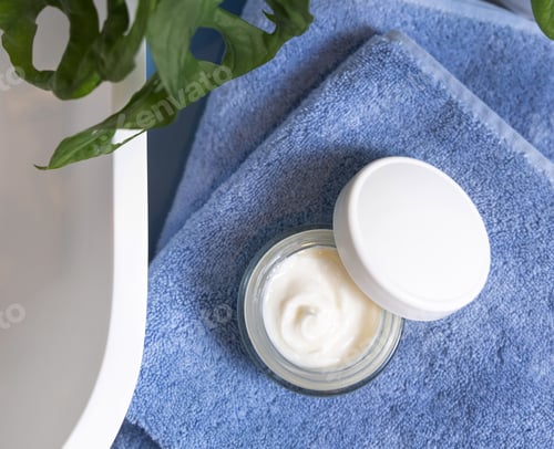 Preview: Opened cream jar on blue towels near basin and green monstera in bath, lid mockup