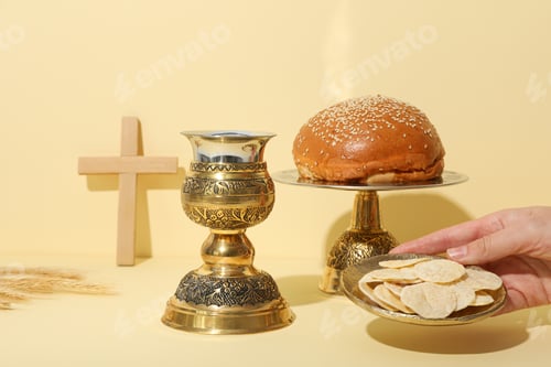 Preview: Wooden cross, bread, hand and cup on light background