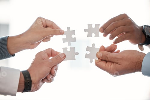Preview: Cropped shot of four unrecognizable businesspeople building a puzzle in the office