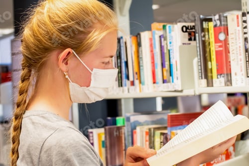 Preview: Girl wearing disposable face mask at the local library during the COVID-19 pandemic