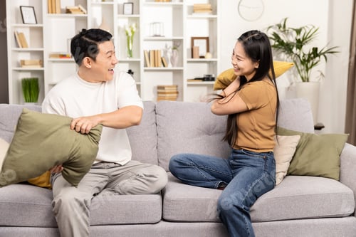Preview: Joyful Couple Having Fun with a Pillow Fight at Home