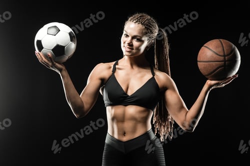 Preview: Beautiful smiling fitness girl holding a basketball ball and soccer ball