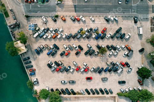 Preview: Large parking lot with colorful cars standing in rows on the seashore. Drone