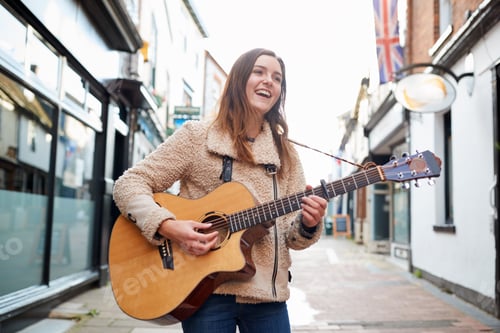 Preview: Female Musician Busking Playing Acoustic Guitar Outdoors In Street