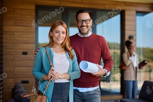 Preview: Happy couple of real estate buyers looking at camera.