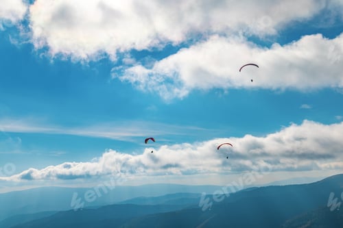 Preview: Paragliding in highland against giant forestry mountains