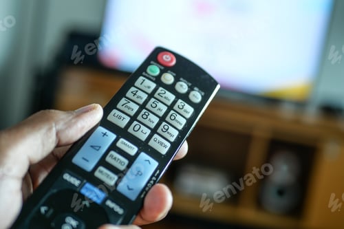 Preview: close up of man hand holding tv remote.