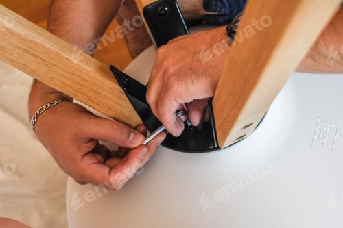 Preview: Closeup shot of a handyman assembling a chair