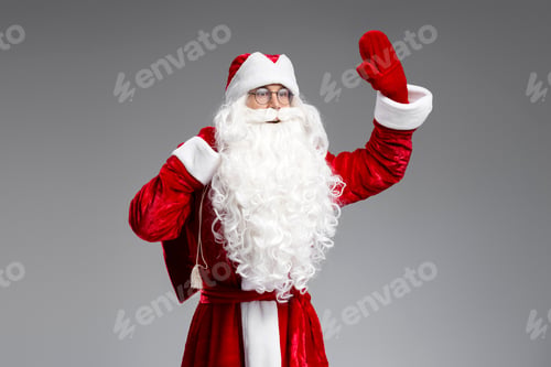 Preview: Saint Nicholas holding bag with gifts waving hand looking away isolated on black background