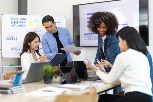 Preview: Young people meeting to discuss successful business projects in the office.