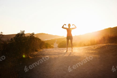 Preview: Female jogger flexing arms in sunlight, Poway, CA, USA