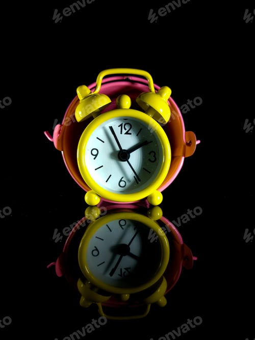 Preview: A yellow clock inside the bucket with reflection on a black background.