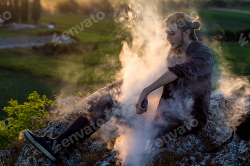 Preview: Handsome young man smoking electronic cigarette.