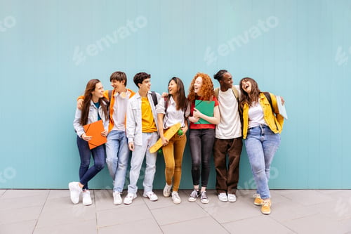 Preview: Happy multiracial students standing over isolated blue background