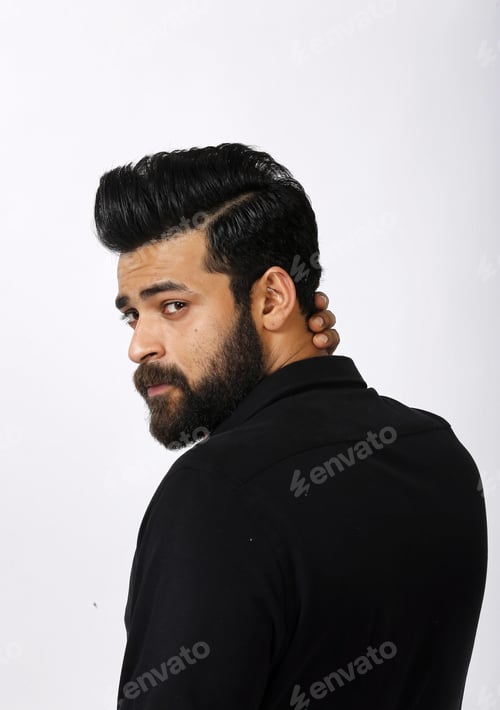 Preview: Vertical shot of a handsome Indian male model with a beard looking back