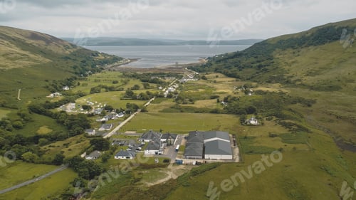 Preview: Scottish whisky distillery at village aerial. Road, houses. Nobody nature landscape of Arran Island