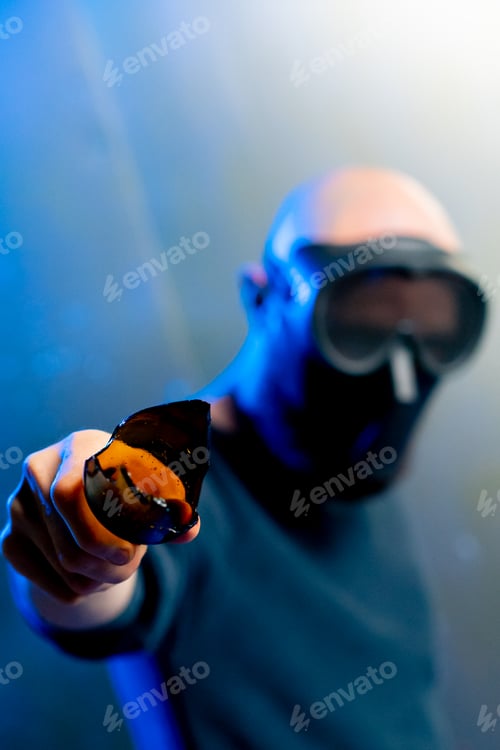 Preview: male robber in a mask holding a broken bottle in his hand threats attack robbery