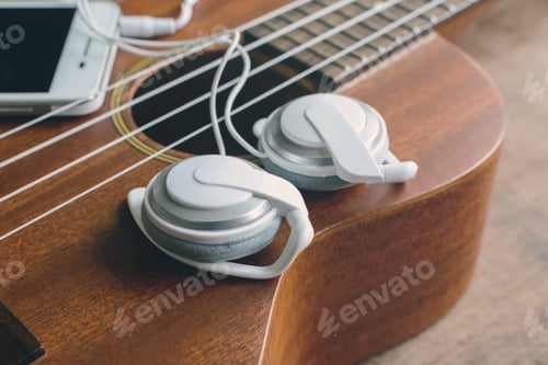 Preview: Ukulele guitar with earphone on wooden table