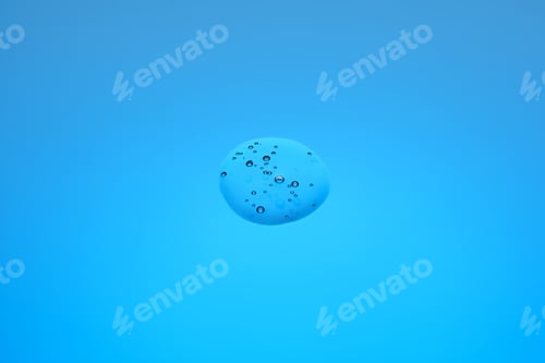 Preview: A drop of cosmetic product or serum on a blue background.