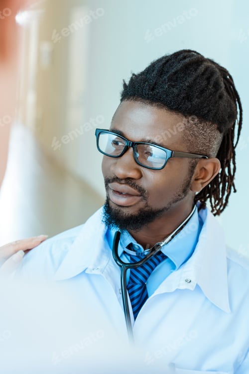 Preview: An african-american medical intern in lab coat and glasses