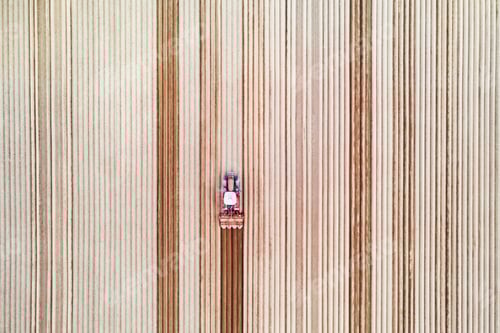 Preview: Lonely tractor on agricultural field with rows of plowed soil