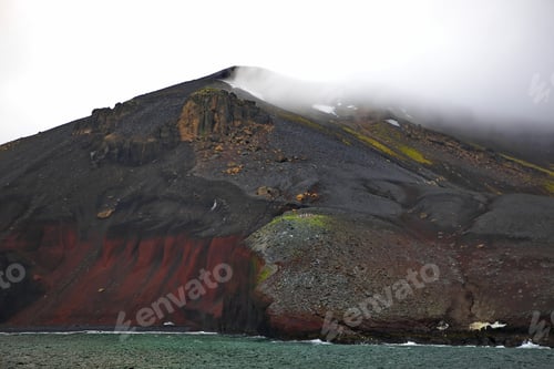 Preview: Big mountain covered with fog and the ocean on the bottom in Antarctica