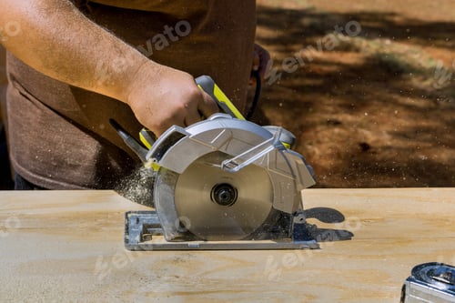 Preview: Working a circular saw while holding it in hand, a worker cuts plywood on a table