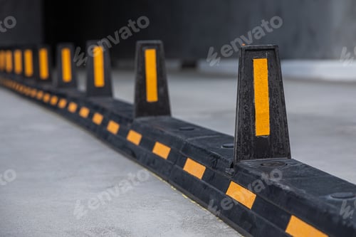 Preview: Road dividers with yellow stripes on road to underground garage