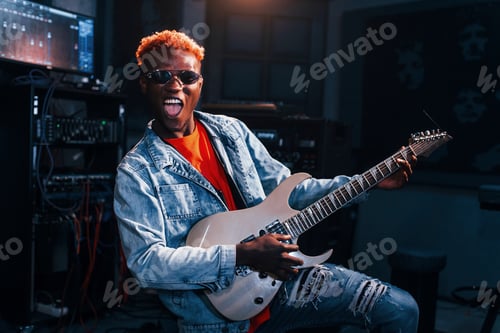 Preview: Plays guitar. Young african american performer rehearsing in a recording studio