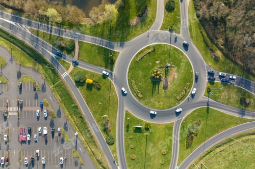 Preview: Aerial view of road roundabout intersection with moving heavy traffic.