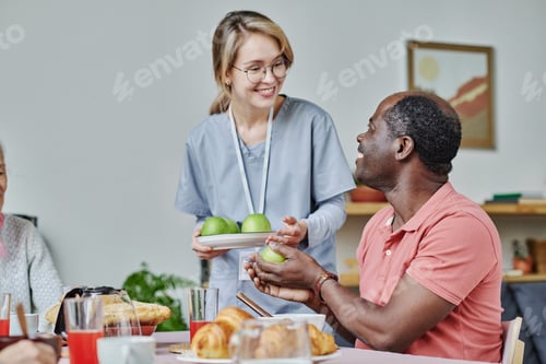 Preview: Caregiver giving apples to senior man