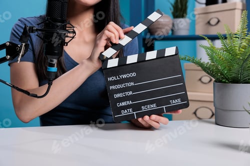 Preview: Film director holding movie slate in front of camera recording videoblog