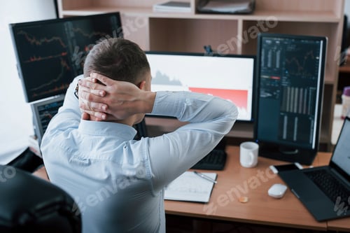 Preview: Man working online in the office with multiple computer screens in index charts