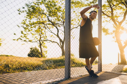 Preview: black man doing sports, playing basketball on sunrise, active lifestyle, sunny summer morning