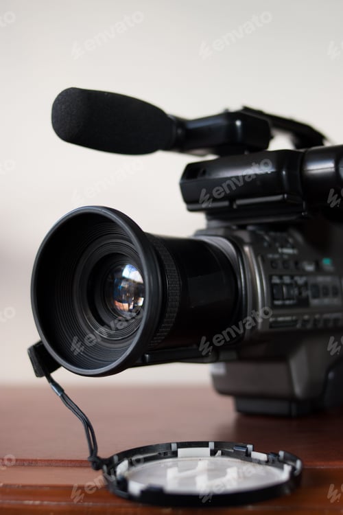 Preview: Closeup of a pro camera on a wooden desk and blurred background