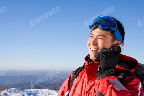 Preview: Young Chinese man in ski gear talking on his mobile phone