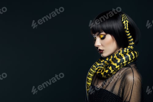 Preview: Beauty woman short haircut python yellow snake on her neck. A yellow snake on the shoulders