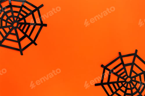 Preview: Halloween festive concept. Decorative spider net on a bright orange background. Flat lay, copy space