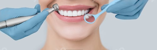 Preview: Cropped perfect smile and dentist hands holding a dental drill and an angle mirror. Dentistry and