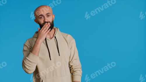 Preview: Man in Hoodie Posing Against a Blue Background