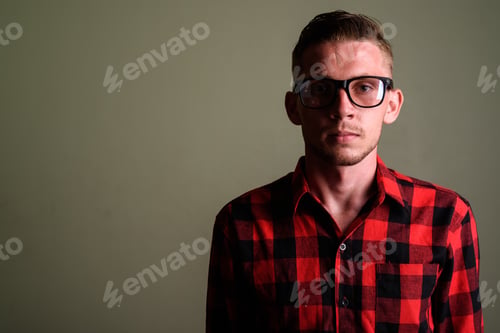 Preview: Young man wearing red checkered shirt against colored background